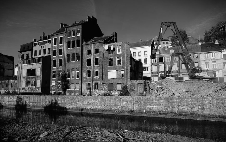 Black and white photo of demolished buildings and construction machinery.